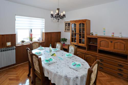 a dining room with a white table and chairs at Apartmani Nena in Ždrelac
