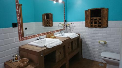 uma casa de banho com 2 lavatórios e um espelho em Casa Vargas em Pedrezuela