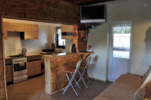 a kitchen with a counter with stools in it at u bażanta in Uherce Mineralne (7)