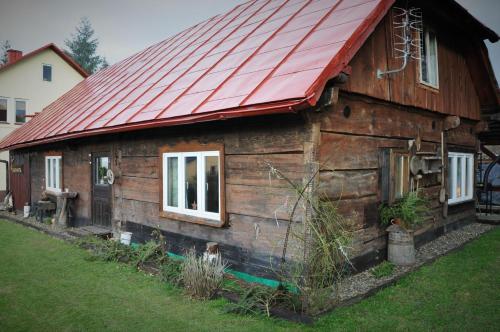 una piccola casa in legno con tetto rosso di u bażanta a Uherce Mineralne