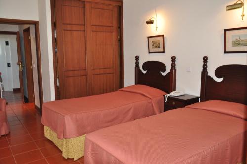 una camera d'albergo con due letti e una porta di Vila Marta a Funchal