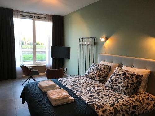 a bedroom with a large bed with a large window at De Kade in Groningen