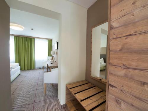 um quarto com uma porta de correr em madeira e um quarto em Landgasthof zum Goldenen Hirschen em Bierbaum am Kleebühel