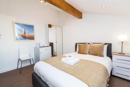 a bedroom with a large bed with a dresser at Riverbank Stay in London