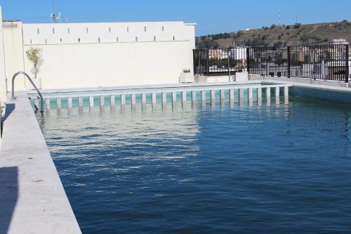 a pool of water in front of a building at Rose's House in Costa da Caparica