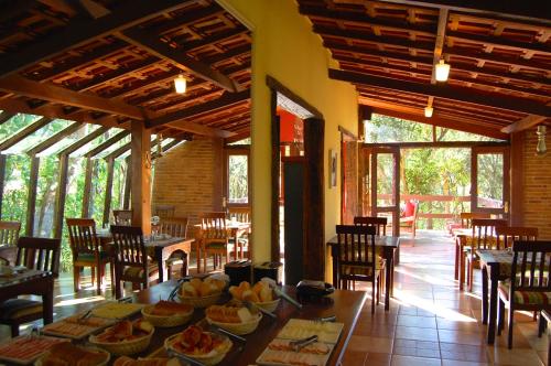 a dining room with a table with food on it at Pássaro de Fogo in Santo Antônio do Pinhal