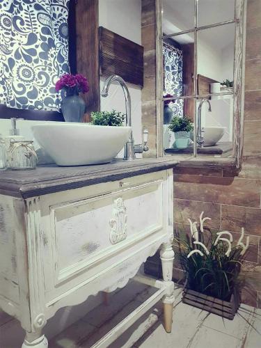 a bathroom with a white sink and a mirror at Dom z bali w Rycerce Górnej in Rycerka Górna