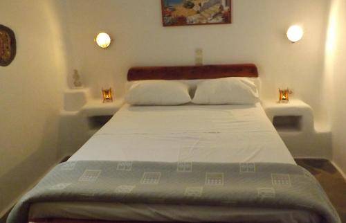 Paliochoriにあるoneiro milosのベッドルーム1室(壁に照明2つ付)