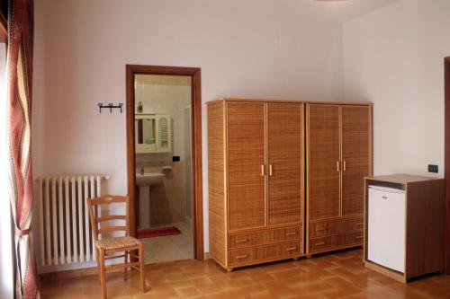 オートラントにあるB&B Otranto 100 mt mareの木製のキャビネット、椅子、鏡が備わる客室です。
