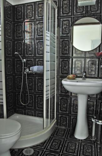 a bathroom with a toilet a sink and a mirror at Aeolis Santorini in Perissa