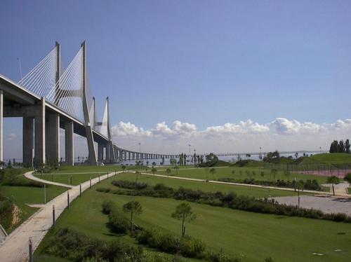 a bridge over a green field next to a road at A View to the River Tejo by SixtyFive Boutique Home in Lisbon