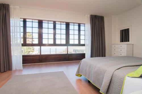 a bedroom with a bed and a large window at Los Rodeos Luxury Vivienda Vacacional in La Laguna