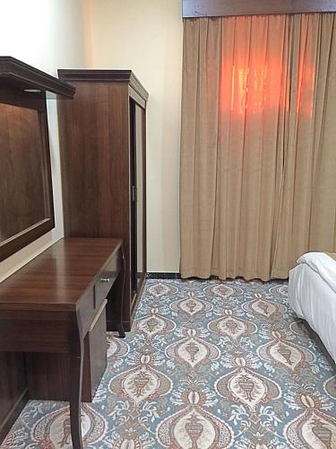 a hotel room with a desk and a bed at شقق الماسة التاج للوحدات السكنية in Hail