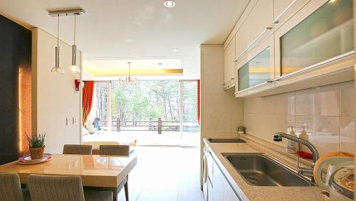 a kitchen with a sink and a table with a dining room at Hugel Heim Pension in Pyeongchang 