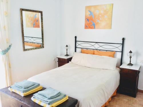 a bedroom with a bed with two mirrors on the wall at Casa Buenavista in Almuñécar