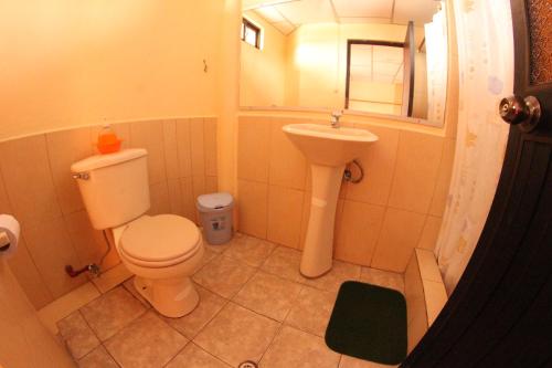 a small bathroom with a toilet and a sink at Hospedaje Germania in Puerto Ayora