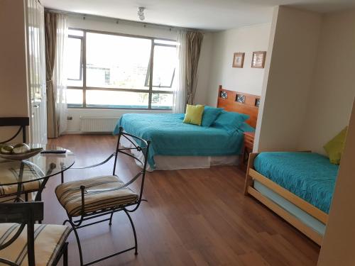 1 dormitorio con 2 camas, mesa y sillas en Pedro de Valdivia Apartment Providencia, en Santiago