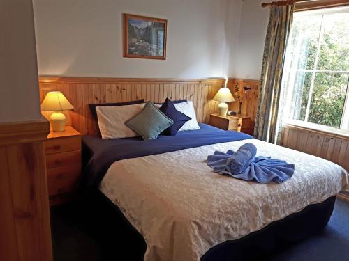 Un dormitorio con una cama con una bata azul. en Sunburst Retreat, en Eildon
