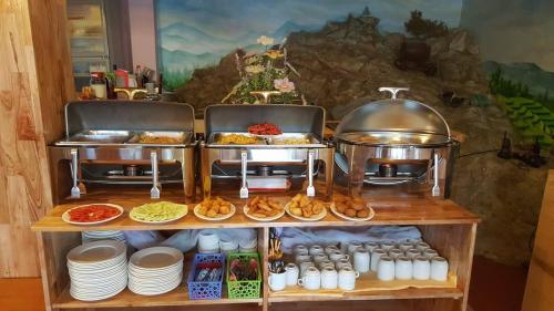 un buffet avec de la nourriture et de la vaisselle sur une étagère dans l'établissement Sapa Scenery Hotel, à Sa Pa