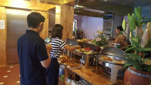 un groupe de personnes préparant des repas sous forme de buffet dans l'établissement Sapa Scenery Hotel, à Sa Pa