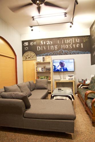 a living room with a couch and a tv at Stay Liuqiu Diving Hostel in Xiaoliuqiu