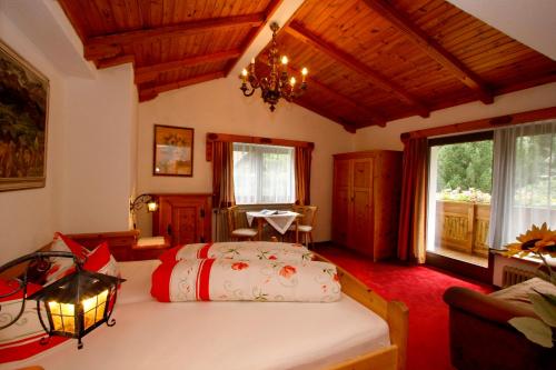 a bedroom with a bed and a table and a window at Apart Piz Mondin in Pfunds