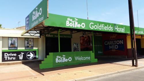 a green building with a sign on the side of the building at Goldfields Hotel Motel in Tennant Creek