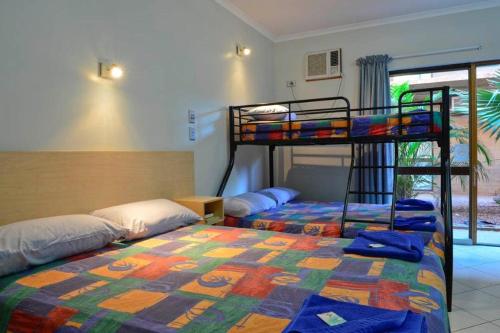 a bedroom with two bunk beds and a window at Goldfields Hotel Motel in Tennant Creek