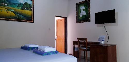 Ένα ή περισσότερα κρεβάτια σε δωμάτιο στο Kusnadi Hotel