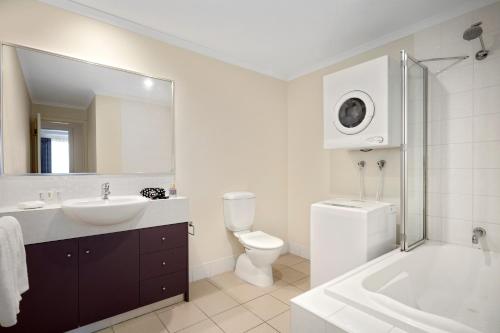 een badkamer met een wastafel, een toilet en een spiegel bij Quest Mont Albert in Box Hill