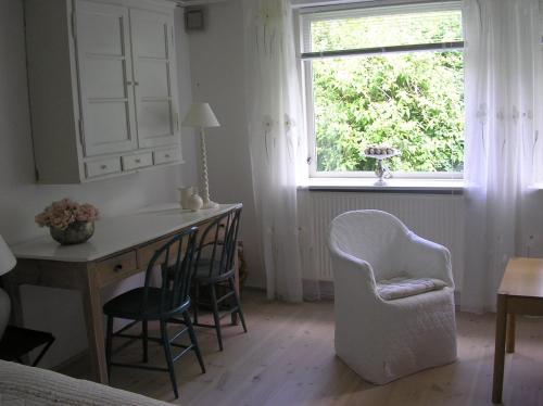 a bedroom with a desk and a chair and a window at Bed & Kitchen Rugbjergvej in Stavtrup