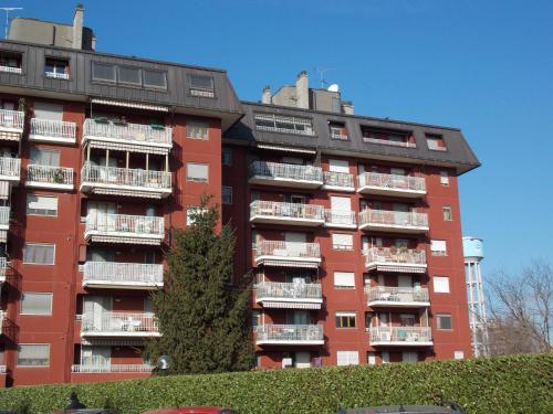 a tall red apartment building with balconies at Assago Forum Apartment in Assago