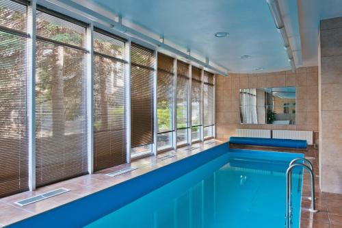 a swimming pool in a room with windows at Best Western Vilnius in Vilnius