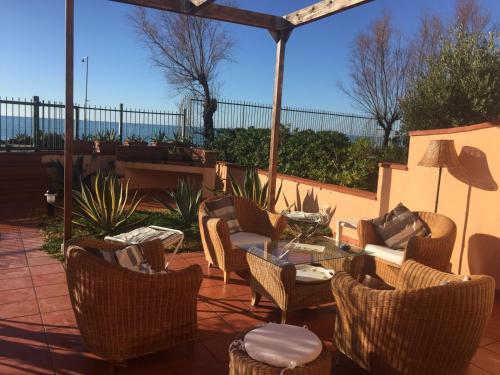 a patio with wicker chairs and a table with at Il terrazzino di Lulù in Cetraro