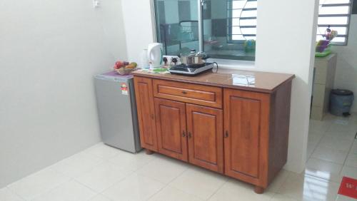 a kitchen with a sink and a refrigerator in a room at MaiHomestay Seri Iskandar in Seri Iskandar