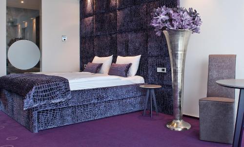 a bedroom with a bed and a vase with flowers at G Design Hotel in Ljubljana