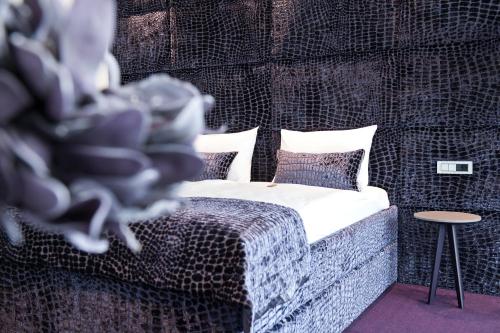 a bedroom with a bed with pillows and a table at G Design Hotel in Ljubljana