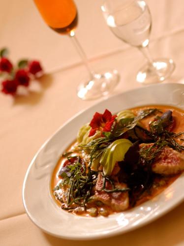 a plate of food on a table with wine glasses at Landhaus Lockwitzgrund in Lockwitz