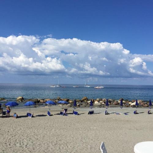 a group of people sitting on a beach with umbrellas at Il terrazzino di Lulù in Cetraro