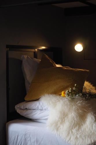 a bed with a pillow and flowers on it at La Malila Hostel in Udon Thani