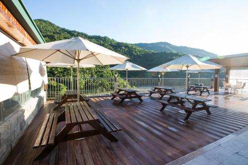 a deck with benches and umbrellas on a building at Dong Tair Spa Hotel in Wenquan