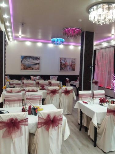a restaurant with white tables with pink bows at Aris Hotel Sofia in Sofia
