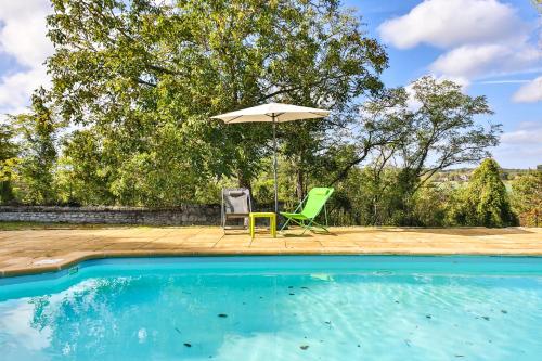 a patio with an umbrella and chairs next to a swimming pool at Les Terrasses De Chaumont 1 in Montsoreau