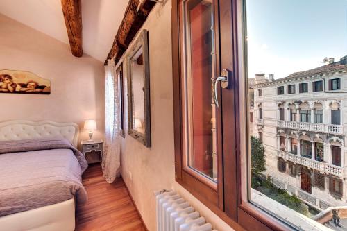 a bedroom with a bed and a large window at The Countess in Venice