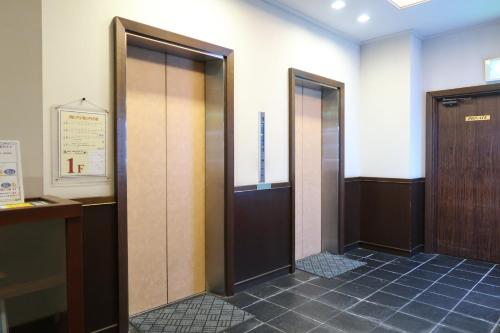 a hallway with two elevators in a building at Fukuno Town Hotel A・Mieux in Nanto