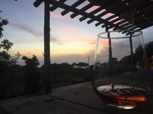 a glass of wine sitting on a table with the sunset at Beso Patara in Patara