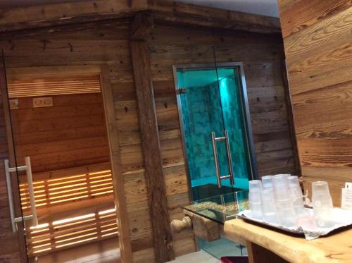a bathroom with a mirror in a wooden wall at Hotel Al Lago in Soraga