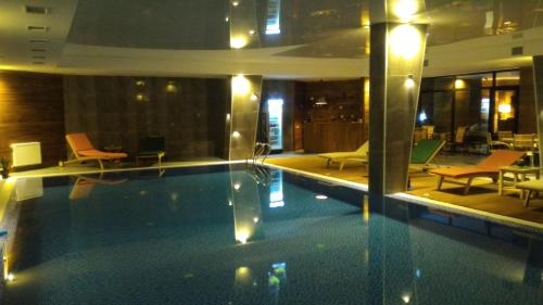 a swimming pool in a hotel with chairs and tables at New Gudauri Sunny studio in Gudauri