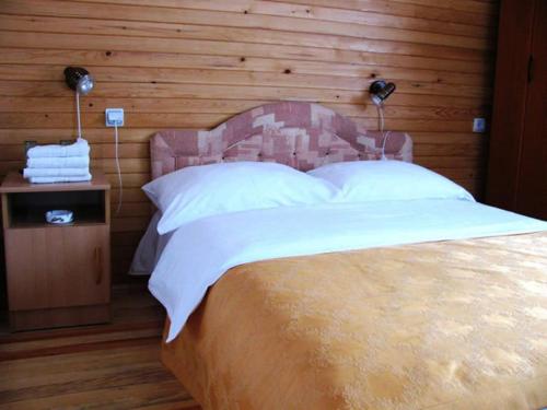 um quarto com uma cama grande e uma parede de madeira em MB Hotel em Žabljak