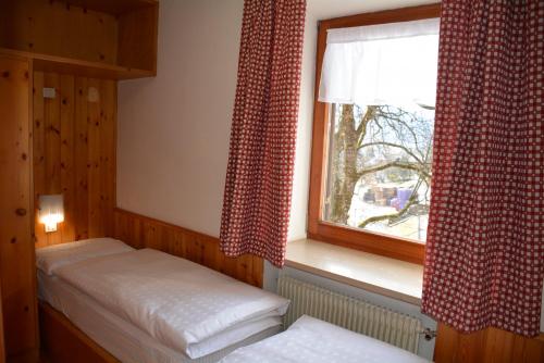 a bedroom with two twin beds and a window at Pilat in Vigo di Fassa